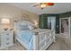 Main bedroom featuring a custom headboard, neutral carpeting, and en-suite bath and walk-in closet at 15422 W Ventura St, Surprise, AZ 85379