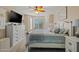Comfortable main bedroom with bay windows, plantation shutters, and a large television at 15422 W Ventura St, Surprise, AZ 85379