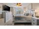 Bright bedroom features a ceiling fan and many windows to let light in, plus a TV on a whitewashed chest of drawers at 15422 W Ventura St, Surprise, AZ 85379