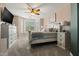 Bright bedroom features a ceiling fan and many windows to let light in, plus a TV on a whitewashed chest of drawers at 15422 W Ventura St, Surprise, AZ 85379