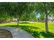 Well-maintained park with lush green grass, mature trees, and a walking path for outdoor recreation at 15422 W Ventura St, Surprise, AZ 85379