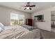 This bedroom offers natural light, TV and dresser, and an opening into the living area at 16415 W Oyer Ln, Surprise, AZ 85387