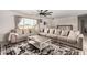 Spacious living room features a large sectional sofa, decorative rug, and neutral color palette at 16415 W Oyer Ln, Surprise, AZ 85387
