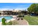 Backyard features a pool, patio seating, a well-manicured lawn, and desert landscaping at 1656 W Meseto Cir, Mesa, AZ 85202