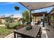 Backyard patio featuring a large dining table under a covered pergola near the pool area at 1656 W Meseto Cir, Mesa, AZ 85202