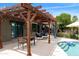 Inviting backyard patio featuring a pergola, ample seating, and a sparkling pool perfect for relaxation at 1656 W Meseto Cir, Mesa, AZ 85202