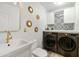 Bright laundry room with modern washer/dryer, patterned backsplash, and stylish gold fixtures at 1656 W Meseto Cir, Mesa, AZ 85202