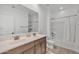Bathroom featuring double sinks, large mirror, tub, and a shower with a sliding shower curtain at 18100 W College Dr, Goodyear, AZ 85395