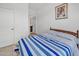 Comfortable bedroom featuring a queen-size bed with a blue and white striped comforter and access to a bathroom at 18100 W College Dr, Goodyear, AZ 85395