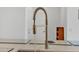 Modern chrome kitchen faucet over stainless steel sink and white quartz countertop at 18100 W College Dr, Goodyear, AZ 85395