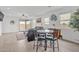 Open living area with a ceiling fan, stone table, leather seating, and views to the outside patio at 18100 W College Dr, Goodyear, AZ 85395