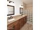Modern bathroom featuring double sinks, granite counters, stylish fixtures, and a glass block shower at 1861 E Bendix Dr, Tempe, AZ 85283