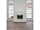 Living room fireplace framed by large windows and light colored wood-look tile flooring at 1861 E Bendix Dr, Tempe, AZ 85283