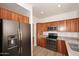 Kitchen with wooden cabinetry and stainless steel appliances, including a refrigerator, microwave, and oven, offering a sleek and functional design at 1861 E Bendix Dr, Tempe, AZ 85283