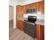 Kitchen featuring wooden cabinets, granite countertops, and stainless steel appliances, including a microwave and oven, providing a modern aesthetic at 1861 E Bendix Dr, Tempe, AZ 85283