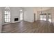 Spacious living room with wood-look tile flooring, white walls, and fireplace at 1861 E Bendix Dr, Tempe, AZ 85283