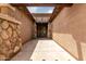 Covered entryway with decorative lighting, stone pillars, and a secure screen door enhancing curb appeal at 18719 E Pelican Ct, Queen Creek, AZ 85142