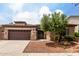 Charming single-story home with a stone-accented facade, a spacious driveway, and a well-maintained front yard at 18719 E Pelican Ct, Queen Creek, AZ 85142