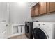 Functional laundry room with a modern washer and dryer set, built-in cabinets, and convenient storage for laundry accessories at 18719 E Pelican Ct, Queen Creek, AZ 85142