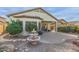 View of the back of the house, with a patio, fountain, desert landscaping and covered porch at 19667 N 260Th N Ln, Buckeye, AZ 85396