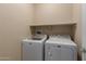 Laundry room featuring a white front-load washing machine and dryer with a shelf above them at 19667 N 260Th N Ln, Buckeye, AZ 85396
