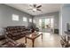 Comfortable living room featuring tile floors, a ceiling fan, and sliding glass doors at 19667 N 260Th N Ln, Buckeye, AZ 85396