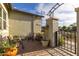 Covered patio area featuring outdoor seating, potted plants, and a wrought iron gate at 19667 N 260Th N Ln, Buckeye, AZ 85396