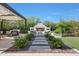 Landscaped backyard featuring an outdoor fireplace, seating area, and covered pergola for elegant outdoor living at 20510 W White Rock Rd, Buckeye, AZ 85396