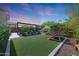 Spacious backyard with a well-maintained lawn, outdoor patio seating, and fireplace, perfect for outdoor living at 20510 W White Rock Rd, Buckeye, AZ 85396