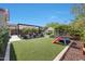 Large backyard with lush lawn, pergola-covered dining area, fireplace, and playground for Gathering enjoyment at 20510 W White Rock Rd, Buckeye, AZ 85396