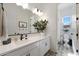 Light and bright bathroom vanity with decorative mirror and an adjacent toilet room at 20510 W White Rock Rd, Buckeye, AZ 85396