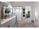 Bright bathroom featuring double vanity, glass shower, and separate tub with hanging plant at 20510 W White Rock Rd, Buckeye, AZ 85396