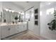 Bright bathroom featuring double vanity, glass shower, and separate tub with hanging plant at 20510 W White Rock Rd, Buckeye, AZ 85396