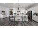 A kitchen island is fitted with counter seating, and white cabinetry with stainless steel appliances at 20510 W White Rock Rd, Buckeye, AZ 85396