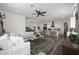 Bright living room featuring a large sectional sofa, ceiling fan, and open access to the kitchen at 20510 W White Rock Rd, Buckeye, AZ 85396