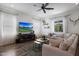 Comfortable living room showcasing a sectional sofa, ceiling fan, and entertainment center at 20510 W White Rock Rd, Buckeye, AZ 85396