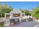 Outdoor seating area with stone tile and a gorgeous fireplace framed by white stucco at 20510 W White Rock Rd, Buckeye, AZ 85396