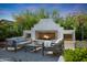 Inviting outdoor living space featuring a stone fireplace with seating and decorative landscaping at 20510 W White Rock Rd, Buckeye, AZ 85396