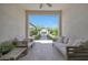 Inviting covered patio with comfortable seating overlooking the outdoor fireplace and beautifully landscaped backyard at 20510 W White Rock Rd, Buckeye, AZ 85396