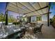 Relaxing outdoor space with a shaded patio area, comfortable seating, dining table, and well-manicured plants at 20510 W White Rock Rd, Buckeye, AZ 85396