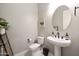 Modern powder room featuring white fixtures, decorative mirror, and neutral wall tones at 20510 W White Rock Rd, Buckeye, AZ 85396