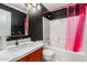 Modern bathroom with a sink vanity and bathtub with pink curtain at 20977 N 84Th Ln, Peoria, AZ 85382
