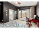 Bedroom featuring a ceiling fan, dark accent wall, and cozy bay window seat at 20977 N 84Th Ln, Peoria, AZ 85382