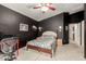 Nicely appointed bedroom with fan, dark accent wall, and wood furnishings at 20977 N 84Th Ln, Peoria, AZ 85382