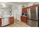 Spacious kitchen showcasing stainless steel refrigerator, wood floors and cabinets at 20977 N 84Th Ln, Peoria, AZ 85382