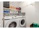 Functional laundry area featuring side-by-side Samsung washer and dryer, and storage shelves at 20977 N 84Th Ln, Peoria, AZ 85382