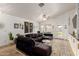 Bright living room with vaulted ceiling, large sectional sofa, decor art and open access to dining area at 20977 N 84Th Ln, Peoria, AZ 85382