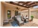 Covered outdoor patio with comfortable seating, ceiling fan, and decorative rug at 20977 N 84Th Ln, Peoria, AZ 85382