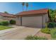Exterior view of a well-maintained home featuring a two-car garage and tile roof at 2154 E Forge Ave, Mesa, AZ 85204