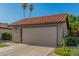 Exterior view of a well-maintained home featuring a two-car garage and tile roof at 2154 E Forge Ave, Mesa, AZ 85204